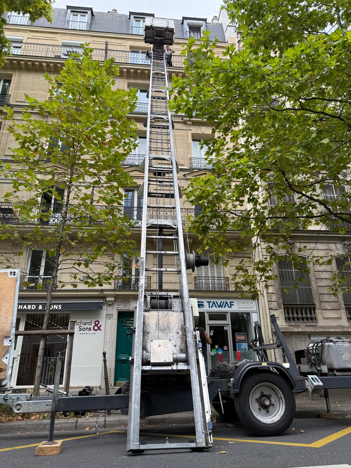 Monte-meuble déployé devant un immeuble haussmannien à Paris